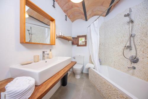 a bathroom with a sink and a tub and a toilet at Els Abats in Sóller