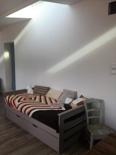 um quarto com uma cama e uma cadeira num quarto em Typique longère pornicaise em Pornic