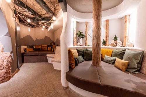 a living room with a couch with pillows at Moseralm Dolomiti Spa Resort in Nova Levante