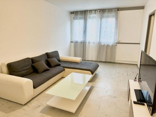 uma sala de estar com um sofá e uma mesa em Superbe T2, Spacieux em Saint-Étienne