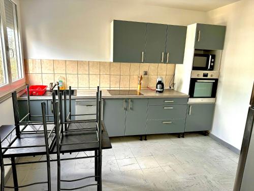 uma cozinha com armários verdes e uma mesa e cadeiras em Superbe T2, Spacieux em Saint-Étienne
