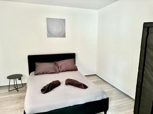 um quarto com uma cama com dois sapatos em Superbe T2, Spacieux em Saint-Étienne