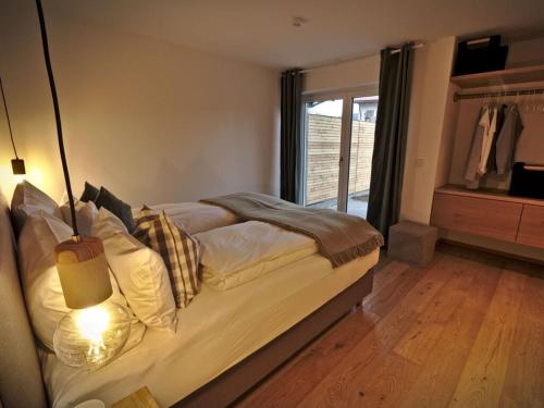 um quarto com uma cama com um candeeiro e uma janela em Lively apartment in Sonthofen em Sonthofen