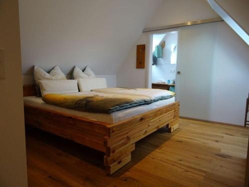 a bedroom with a bed on a wooden floor at Holiday apartment Kieschtock in Unterkirnach