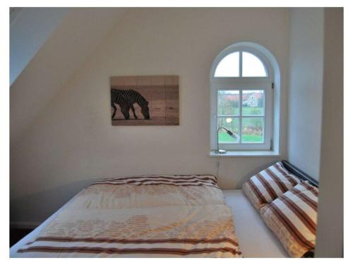 a bedroom with a bed and a window at Holiday apartment Old Warehouse in Münster