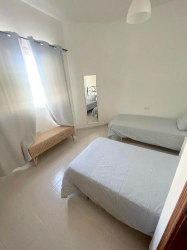 a bedroom with two beds and a mirror at Mareal in La Restinga
