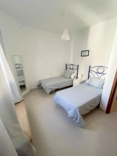 a room with two beds and a mirror in it at Mareal in La Restinga