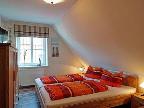 - une chambre avec un lit doté d'oreillers orange et une fenêtre dans l'établissement Apartment in Lancken-Granitz, à Lancken-Granitz