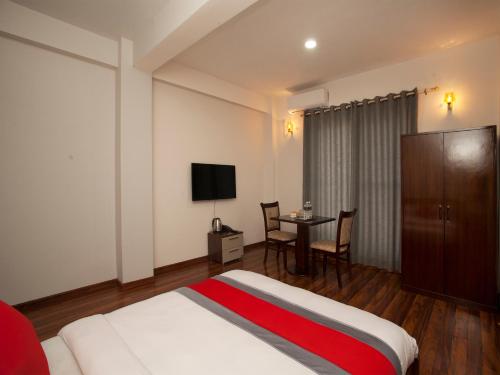 Schlafzimmer mit einem Bett und einem Tisch mit einem TV in der Unterkunft Hotel Euro in Kathmandu