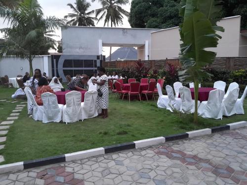 un grupo de personas sentadas en sillas en un evento en Family Ties en Bagamoyo