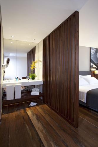 a bedroom with a bed and a sink and a mirror at Hotel Estelar Parque de la 93 in Bogotá