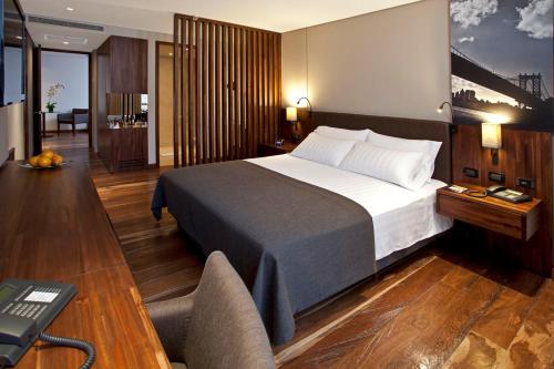 a bedroom with a bed and a desk with a computer at Hotel Estelar Parque de la 93 in Bogotá