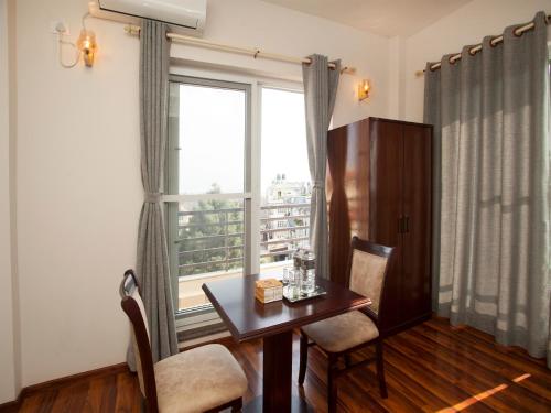 ein Esszimmer mit einem Tisch und einem Fenster in der Unterkunft Hotel Euro in Kathmandu