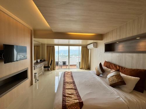a hotel room with a large bed with a television at Condo Minium Patong Phuket in Patong Beach