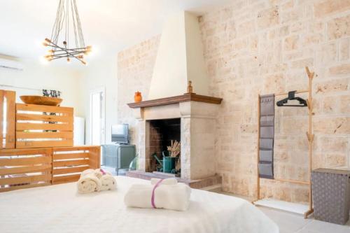1 dormitorio con chimenea y toallas en la cama en Logement vue sur les oliviers, en Le Lamie di Olimpe