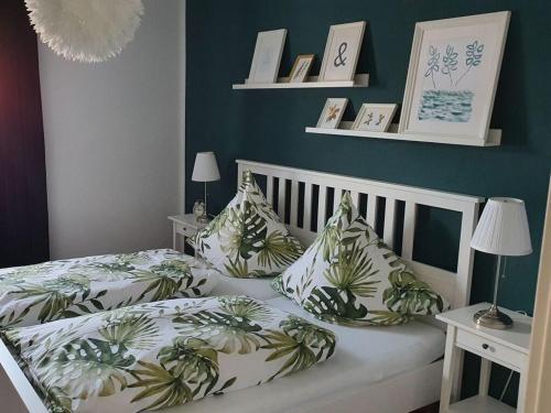 una camera da letto con un letto bianco e cuscini tropicali di "On Lindenallee" a Bad Rothenfelde