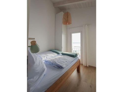 Habitación pequeña con cama y ventana en House in reed 1 - apartment 4, en Neukieritzsch