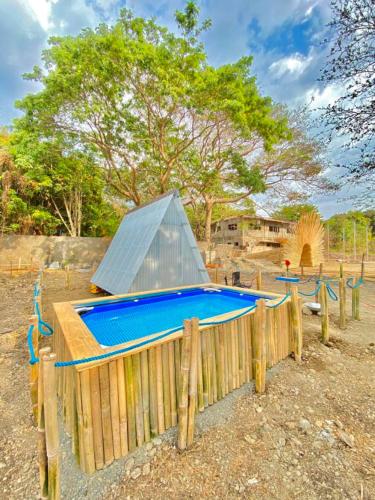 a playground with a blue slide on a wooden fence at Camp Baroro in Bacnotan