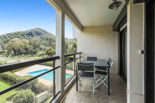 einen Balkon mit einem Tisch und Stühlen sowie Poolblick in der Unterkunft Appartement Tavernia - Welkeys in Mandelieu-la-Napoule