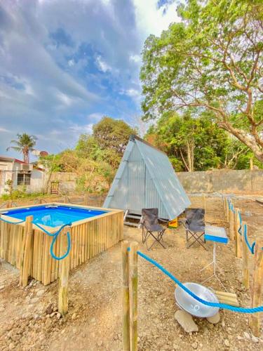 een achtertuin met een zwembad en een tent bij Camp Baroro in Bacnotan