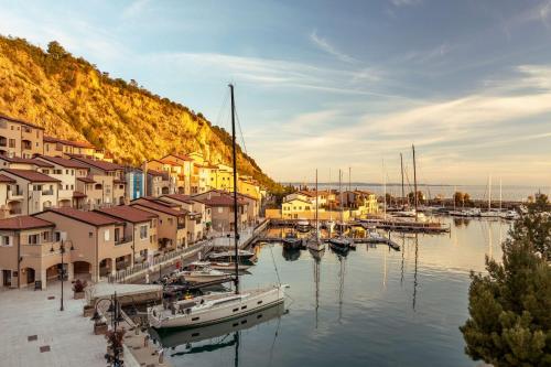 eine Gruppe von Booten, die in einem Yachthafen mit Gebäuden angedockt sind in der Unterkunft Tivoli Portopiccolo Sistiana Wellness Resort & Spa in Sistiana