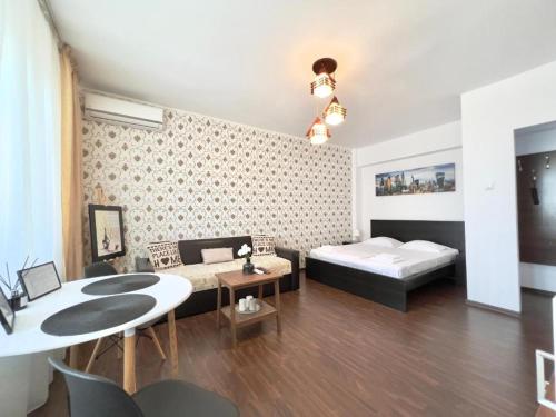 een woonkamer met een bed en een tafel bij Mercur Home in Ploieşti