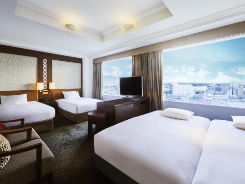 a hotel room with two beds and a large window at ANA Crowne Plaza Chitose by IHG in Chitose