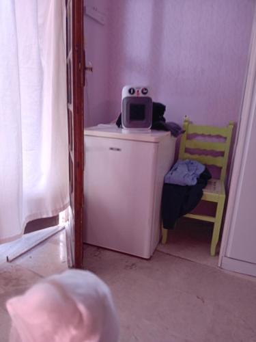 a small room with a tv on top of a refrigerator at Μαρια in Agia Marina Aegina