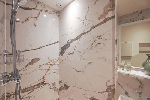 a bathroom with a marble shower with a shower head at Elegant studio avenue Montaigne in Paris