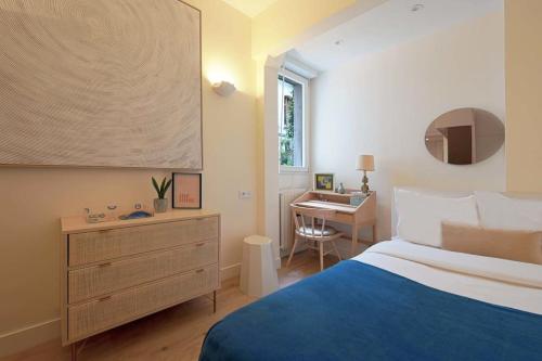 a bedroom with a blue bed and a desk at Elegant studio avenue Montaigne in Paris