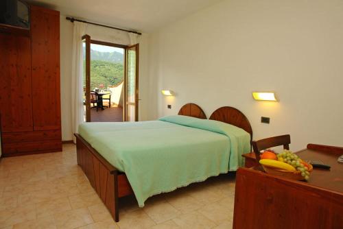 - une chambre avec un lit et une table avec des fruits dans l'établissement Hotel Garnì Al Poggio, à Tignale