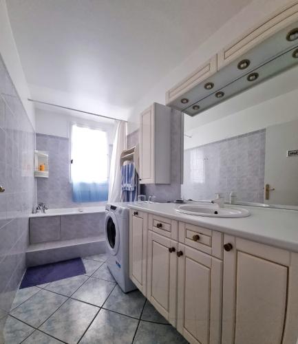 uma casa de banho com um lavatório e uma máquina de lavar roupa em Chambre à 20 min de Paris em Crosne