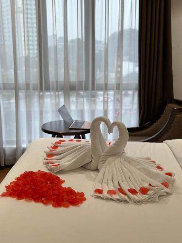 two white swans making a heart on a bed at 22Land Residence Hotel & Spa Hanoi in Hanoi