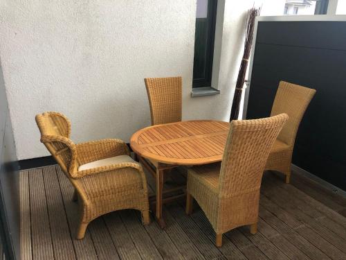 mesa de madera, 2 sillas y mesa y sillas de madera. en Apartment house Calmsailing B rgerende, en Börgerende-Rethwisch