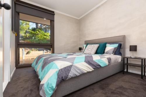 a bedroom with a large bed and a window at Mudbrick house in Gembrook