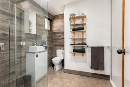 a bathroom with a toilet and a sink and a shower at Mudbrick house in Gembrook