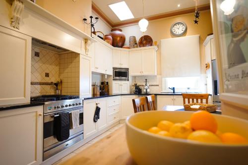 a kitchen with a bowl of oranges on a table at The Red Door: Expansive Home/Pool/4 BR w Ensuites in Glenelg