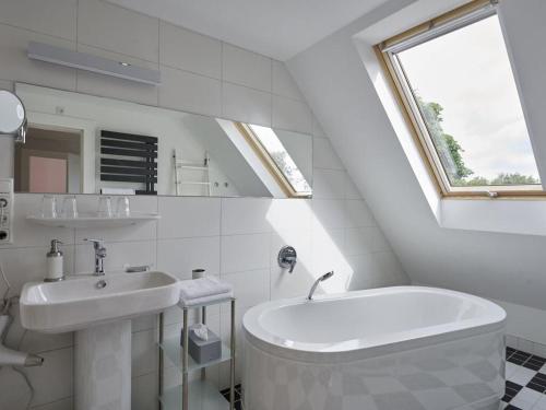 un bagno bianco con lavandino e vasca di Holiday home Altes Zollhaus No 19 a Höfen
