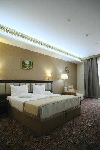 een hotelkamer met een groot bed en een bank bij Konyak Hotel in Jerevan