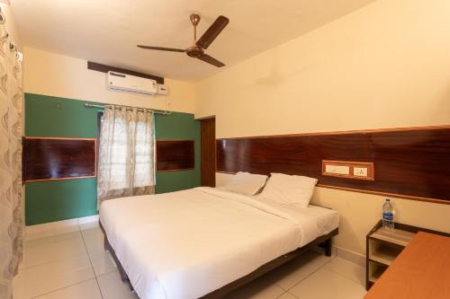 a bedroom with a bed and a ceiling fan at JK Lodge in Kottayam