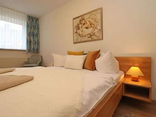 - une chambre avec un grand lit blanc et une lampe dans l'établissement Apartment in Ostseebad Ahrenshoop, à Wustrow