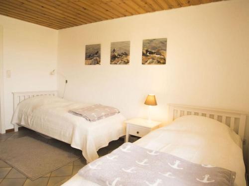 - une chambre avec 2 lits et 2 photos sur le mur dans l'établissement Holiday apartment Oystercatcher, à Ockholm