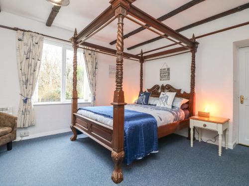 a bedroom with a canopy bed with a blue comforter at Lighthouse in Penzance