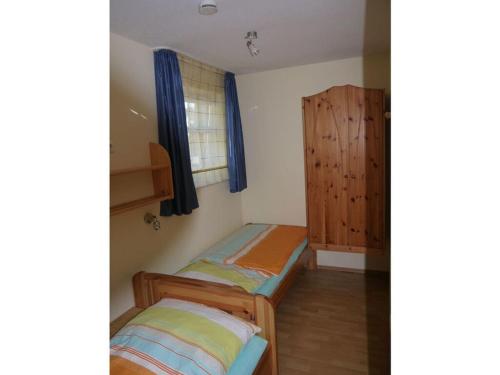 1 Schlafzimmer mit 2 Betten und einem Holzschrank in der Unterkunft 1 in Haus Weser 1 in Cuxhaven