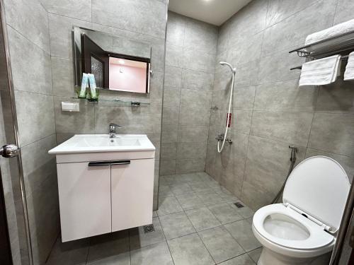 a bathroom with a toilet and a sink and a shower at Forgather B&B in Sanmin