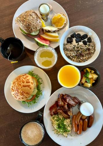 a table with plates of breakfast food on it at Best Western Hotel Botnia in Umeå