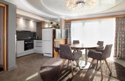 a kitchen with a table and chairs in a room at Grütter Luxury Apartments in Ischgl