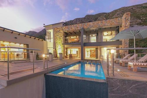 a house with a swimming pool in front of it at Waterstone Villa in Hermanus