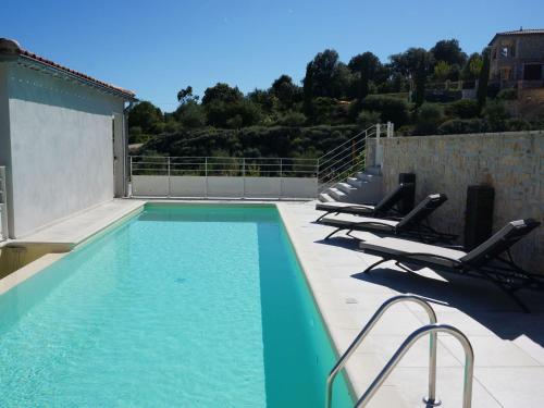 een zwembad met ligstoelen op een patio bij Magnificent Villa in Saint Ambroix with Private Pool in Saint-Ambroix