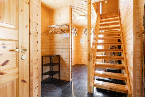 a wooden cabin with a wooden staircase in a room at Himos Jimi 8hlö mökki porealtaalla, Ei lisäkuluja! in Jämsä